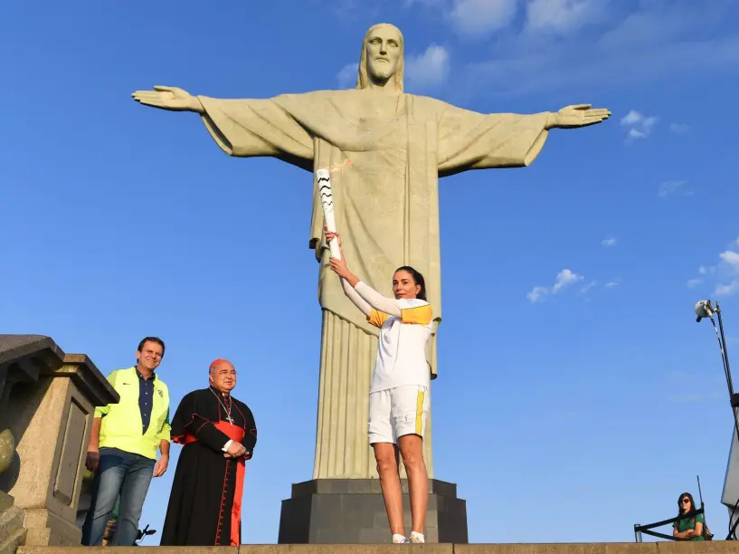 Ex-Volleyball-Olympiateilnehmerin Isabel mit der Flamme vor der weltberühmten Statue.