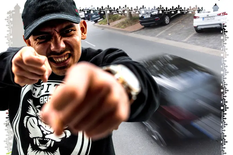 Deutschrapper Capital Bra schaut grimmig in die Kamera. Im Hintergrund ist ein fahrendes Auto zu sehen. (24hamburg.de-Montage)